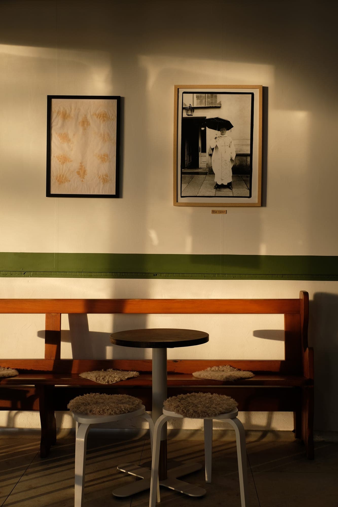 Bakery seating with the church pew beneath a portrait of the vicar
