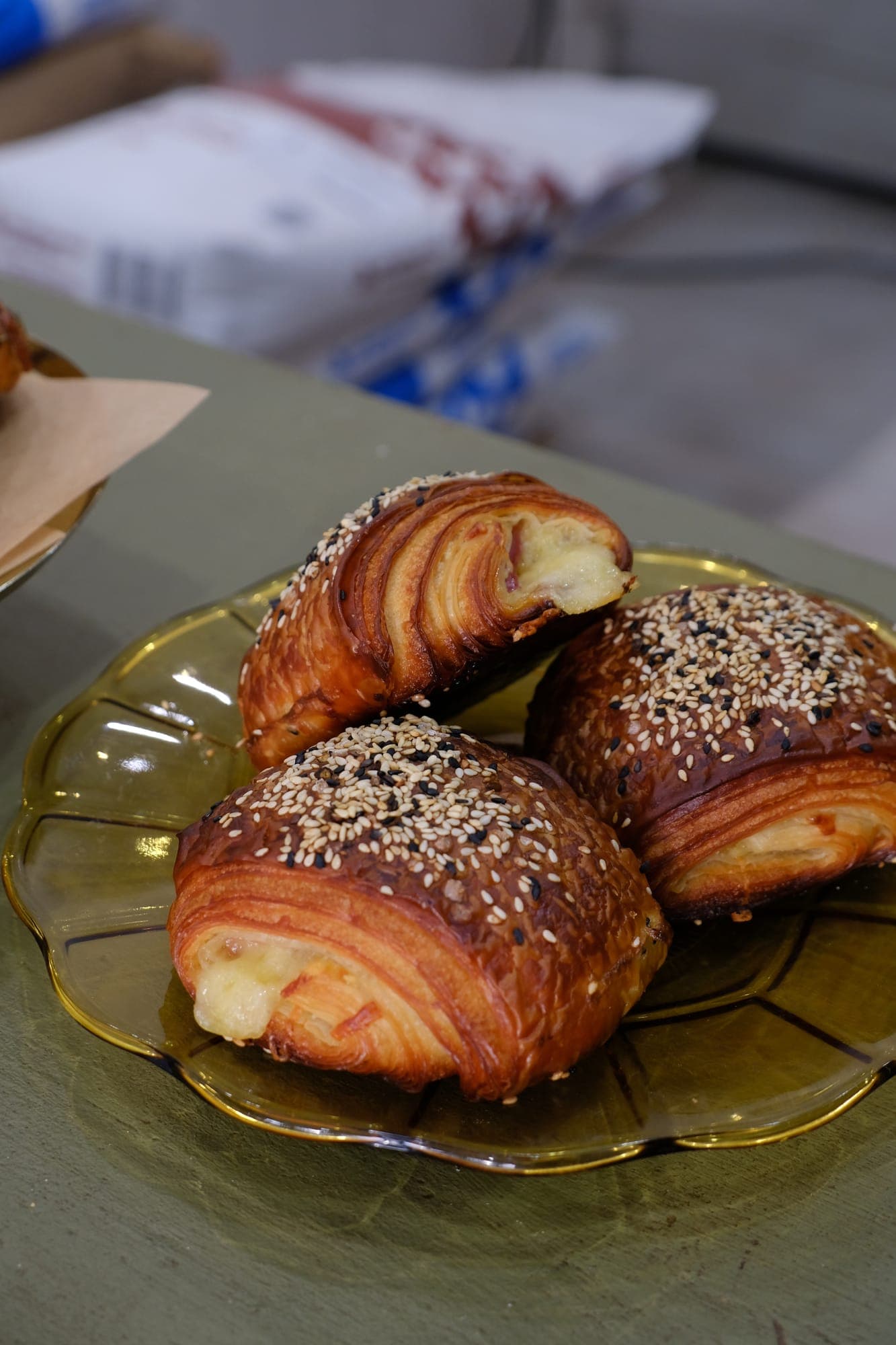 Sesame-topped croissants on a gold plate